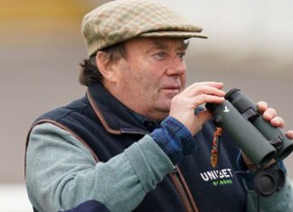 Nikki Henderson’s Steady Tour: Rookie Stars Put together For The Nice Conflict Trainer Nicky Henderson watching horses gallop at Newbury