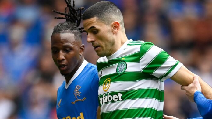 GLASGOW, SCOTLAND - AUGUST 29: Celtic&#39;s Tom Rogic (centre) holds off Joe Aribo (left) and Steve Davis during a cinch Premiership match between Rangers and Celtic at Ibrox, on August 29, 2023, in Glasgow, Scotland (Photo by Rob Casey / SNS Group)