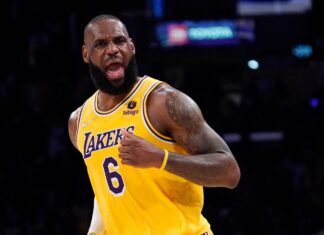 Los Angeles Lakers forward LeBron James celebrates after scoring during the second half of an NBA basketball game against the Dallas Mavericks