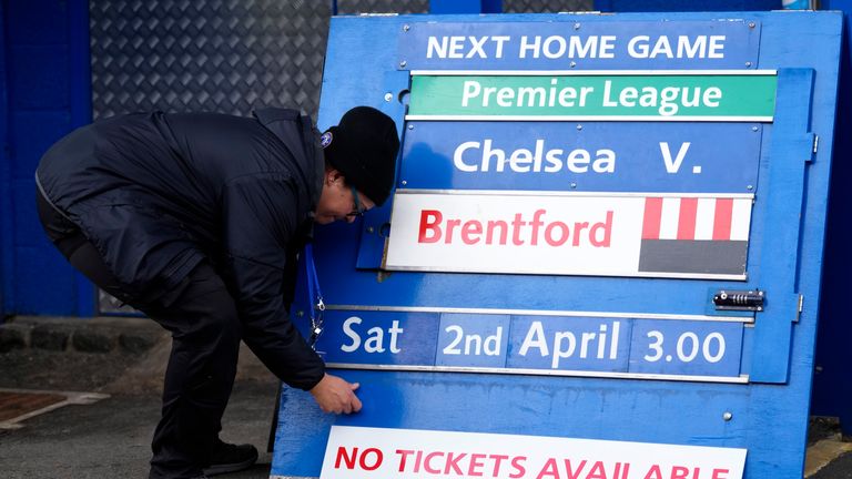 A member of the ground staff adjusts the board for the upcoming match before the English Premier League football match between Chelsea and Newcastle United at Stamford Bridge in London, Sunday, March 13, 2023