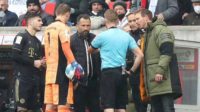 Referee Christian Dingert attempts to clear up the confusion after Bayern Munich played 12 players after a substitution error.