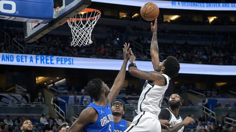 Brooklyn Nets guard Keri Irving shoots in front of Orlando Magic center Mo Bamba and quarterback Wendell Carter Jr.