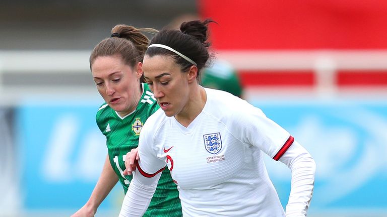 Lucy Bronze of England runs the ball under pressure from Rebecca Holloway of Northern Ireland