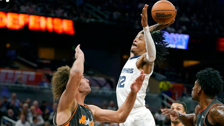 Memphis Grizzlies guard Ja Morant (12) beats Orlando Magic center Robin Lopez (33) to submerge during the second half of an NBA basketball game, Saturday, Feb. 5, 2023, in Orlando, Florida (AP Photo/John Raoux)