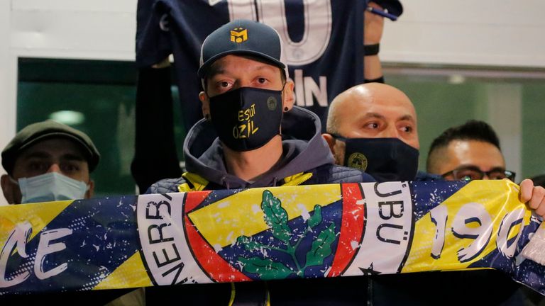 Mesut Ozil holds the Fenerbahce scarf high upon his arrival in Turkey