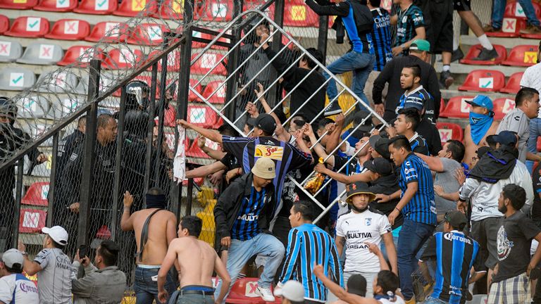 Fans clash during a Mexican soccer league match between host Queretaro and Atlas of Guadalajara, at Corregidora Stadium, in Queretaro, Mexico, Saturday, March 5, 2023. Several people were injured during the melee, including two in critical condition.  (AP Photo/Sergio Gonzalez)
