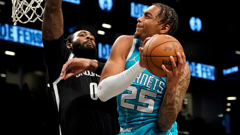 Charlotte Hornets forward PJ Washington (25) scores a shot past Brooklyn Nets Andre Drummond (0) in the first half of an NBA basketball game, Sunday, March 27, 2023, in New York.