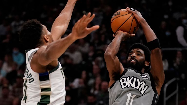 Brooklyn Nets'  Kyrie Irving kicks past Milwaukee Bucks'  Giannis Antetokounmpo during the first half of an NBA basketball game on Saturday, February 26, 2023, in Milwaukee.