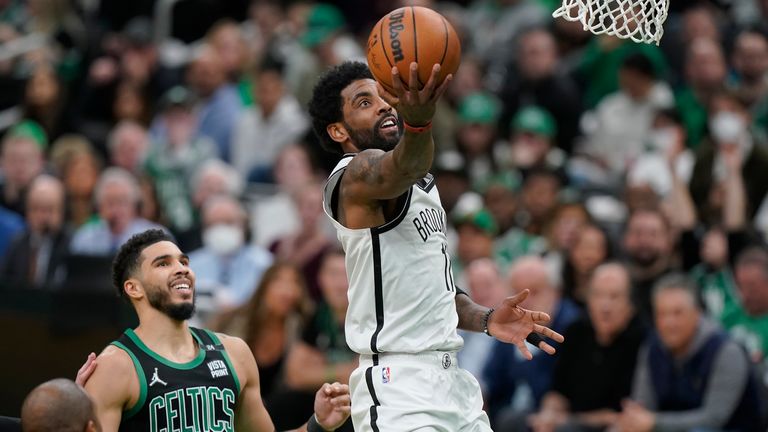 Brooklyn Nets guard Keri Irving (11) drives to the basket as Boston Celtics forward Jason Tatum (0) looks on in the second half of Game 1 of the first round of the Eastern Conference Basketball Tournament of the NBA, Sunday, April 17, 2023, in Boston.  The Celtics won 115-114.