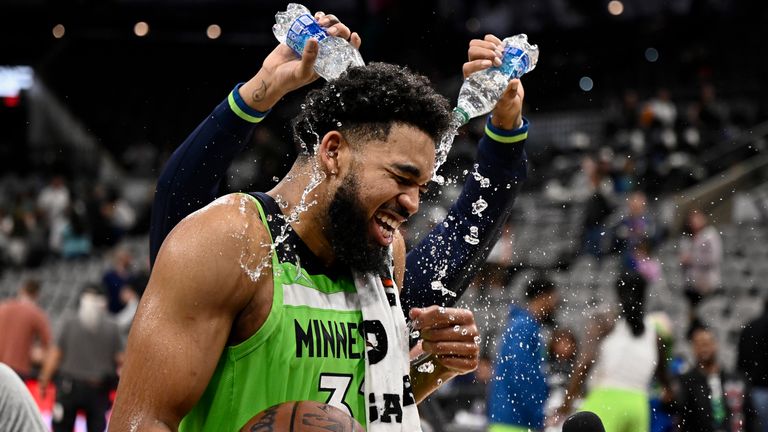 Minnesota Timberwolves center, Karl-Anthony Towns, drowned by teammate D''  Angelo Russell, rear, after an NBA basketball game against the San Antonio Spurs on Monday, March 14, 2023, in San Antonio. 