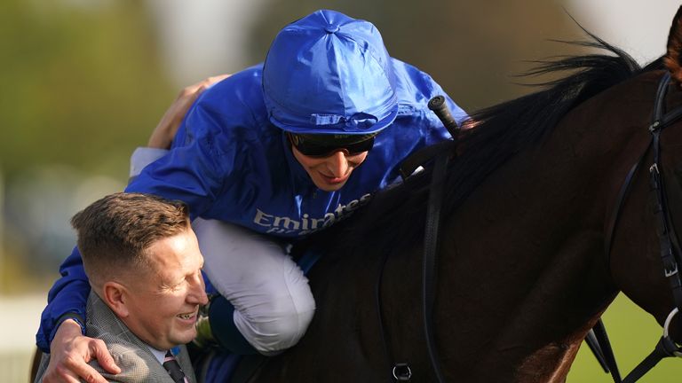 William Buick celebrates with a member of Charlie Appleby's team after beating the Native Trail at Dewhurst Stakes